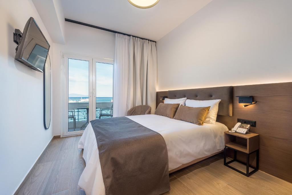 1 dormitorio con cama y ventana grande en Lesvion Hotel, en Mytilini
