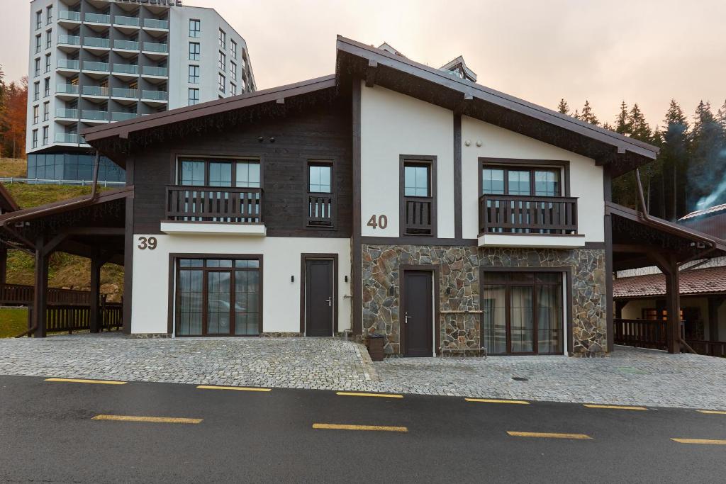 a white and black house on the side of a street at Mountain Residence 4* in Bukovel