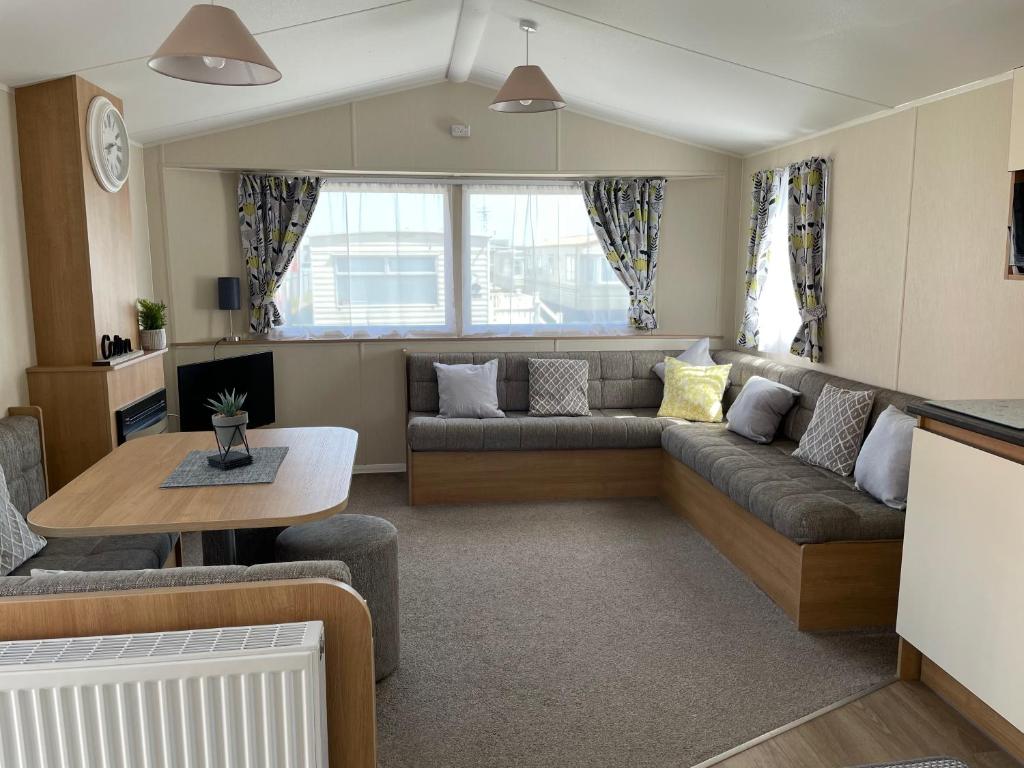 ein Wohnzimmer mit einem Sofa und einem Tisch in der Unterkunft Coastfields 3 bed 8 berth holiday home in Ingoldmells