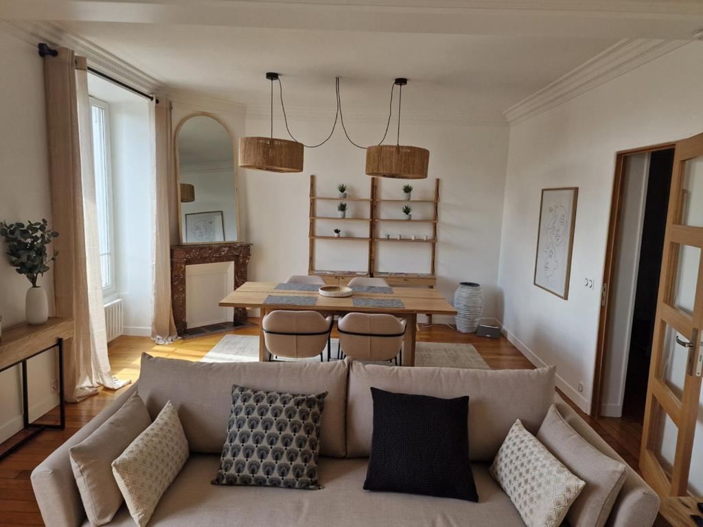 a living room with a couch and a table at Grand Appart 2 pièces Enghien-les-Bains in Enghien-les-Bains