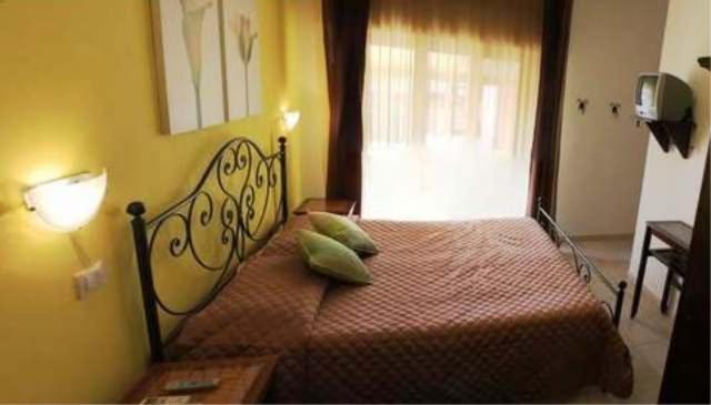 a bedroom with a bed with two green pillows at B&B Viadelmare in Alghero