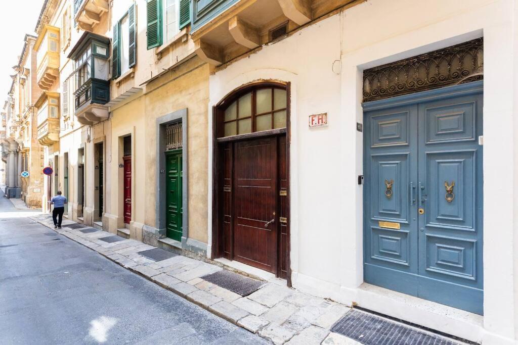 un edificio con puertas azules en el lateral de una calle en Valletta Archbishop 2, en La Valeta