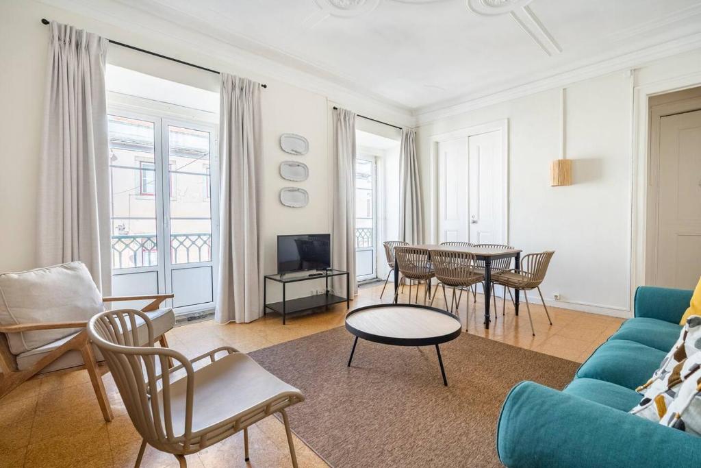 Una sala de estar con un sofá azul y una mesa. en Combro by Patio 25, en Lisboa
