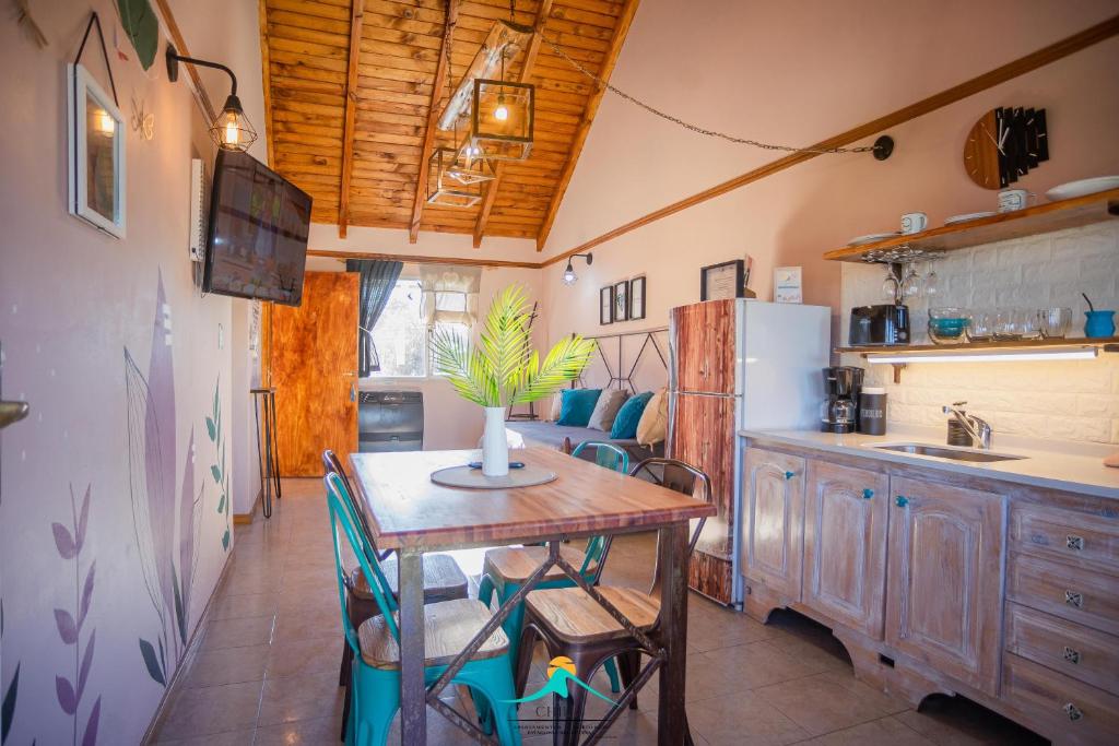 een keuken met een tafel en een koelkast bij Apartamentos Chill in El Bolsón