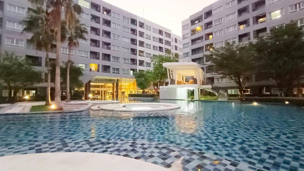 a large swimming pool in front of a building at Elio Del Ray in Bangkok