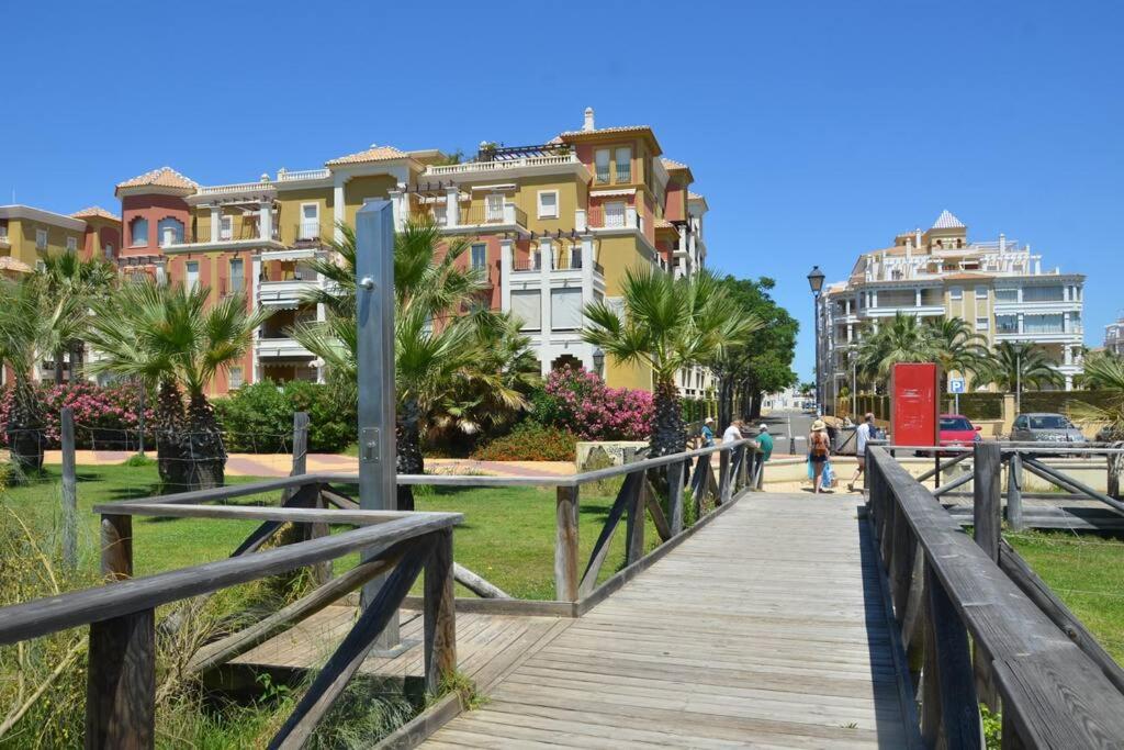 un paseo marítimo de madera frente a algunos edificios en Luxury Apartment in Marina de Isla Canela- Beach Front, en Huelva