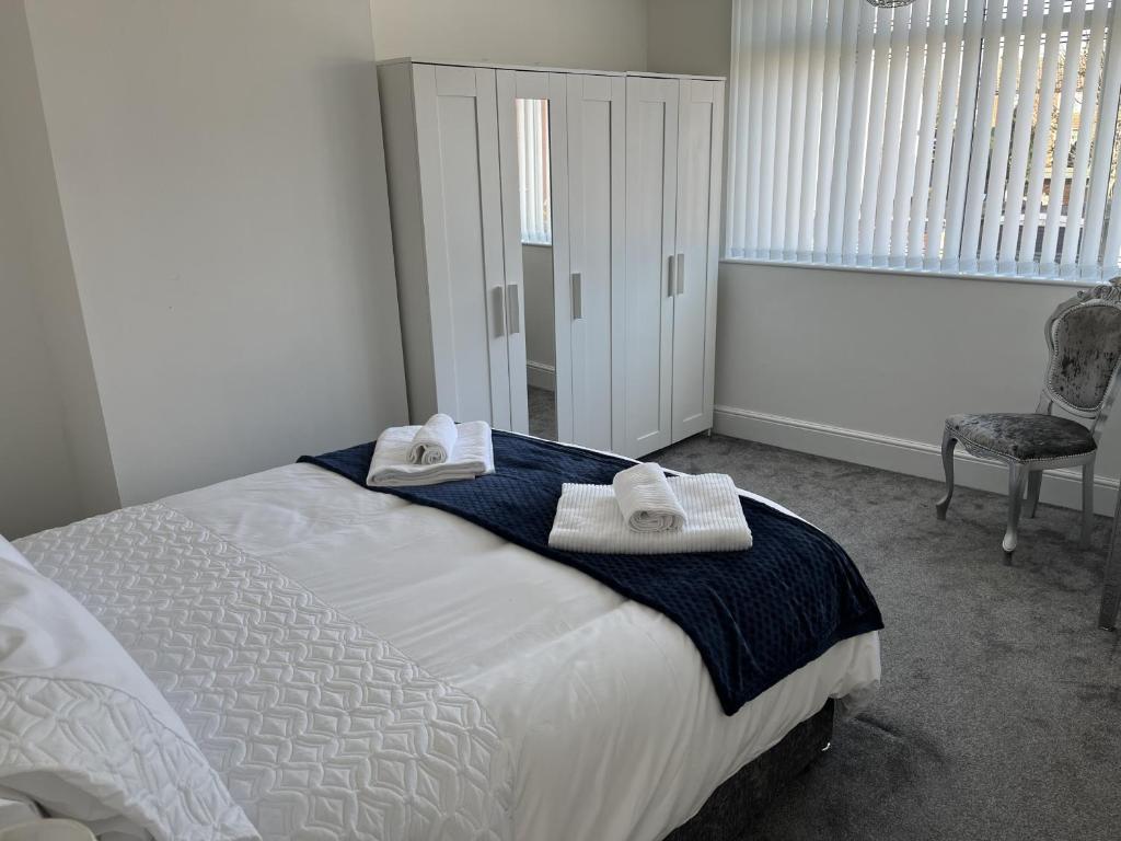 a bedroom with a bed with towels on it at M1Link 3 bed house up to 7 people free parking, wifi, M1, transport links, enclosed L garden in Sutton in Ashfield