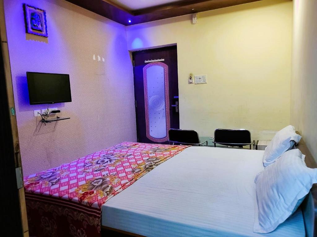 STAYMAKER Madhuwan Heights في Bokāro: غرفة نوم بسرير كبير وتلفزيون