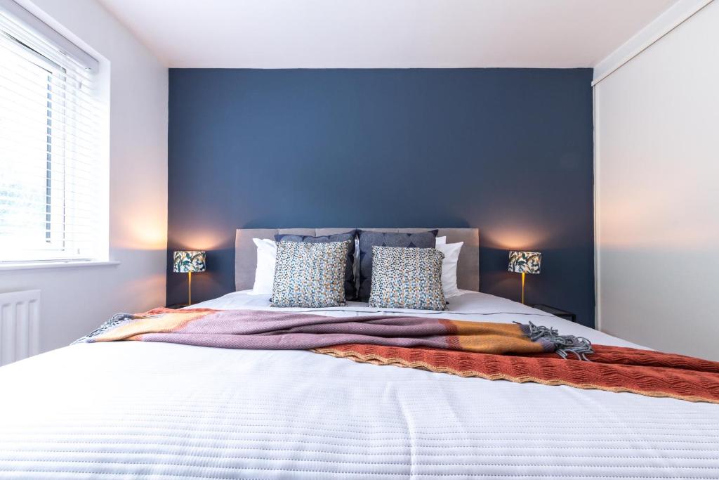 a bedroom with a large bed with a blue wall at Deepdene Close in Reading