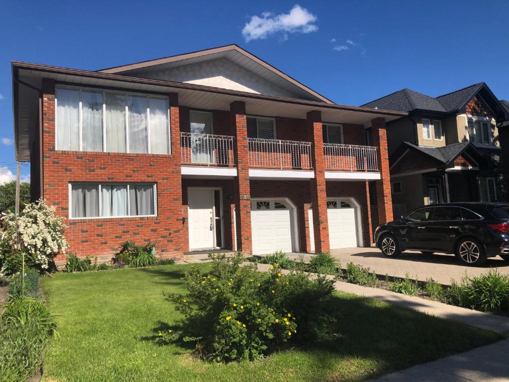 una casa de ladrillo con un coche aparcado en la entrada en Cheerful Room with private bathroom en Calgary