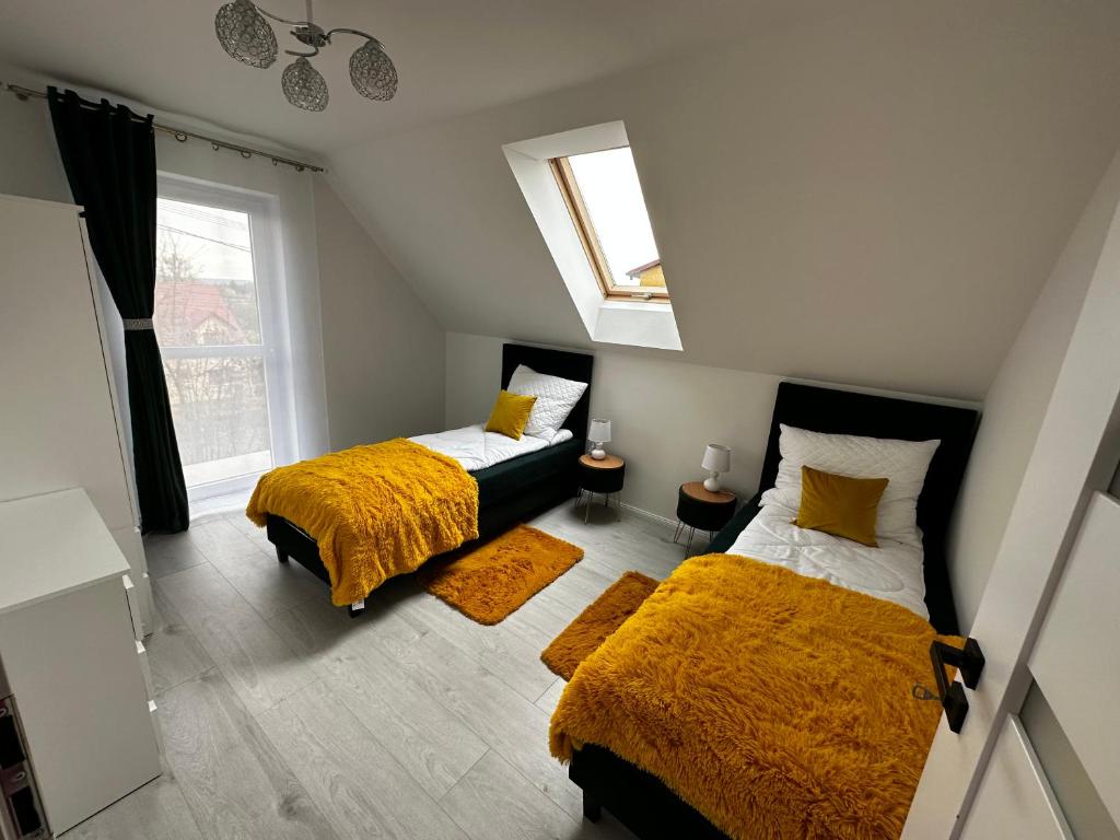 - une chambre avec 2 lits et une fenêtre dans l'établissement Agroturystyka Parcele, 