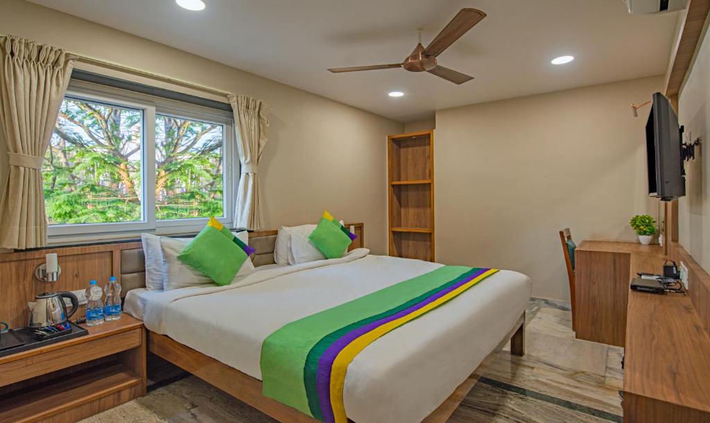 a bedroom with a large bed and a window at Treebo Trend Gyani's in Jamshedpur