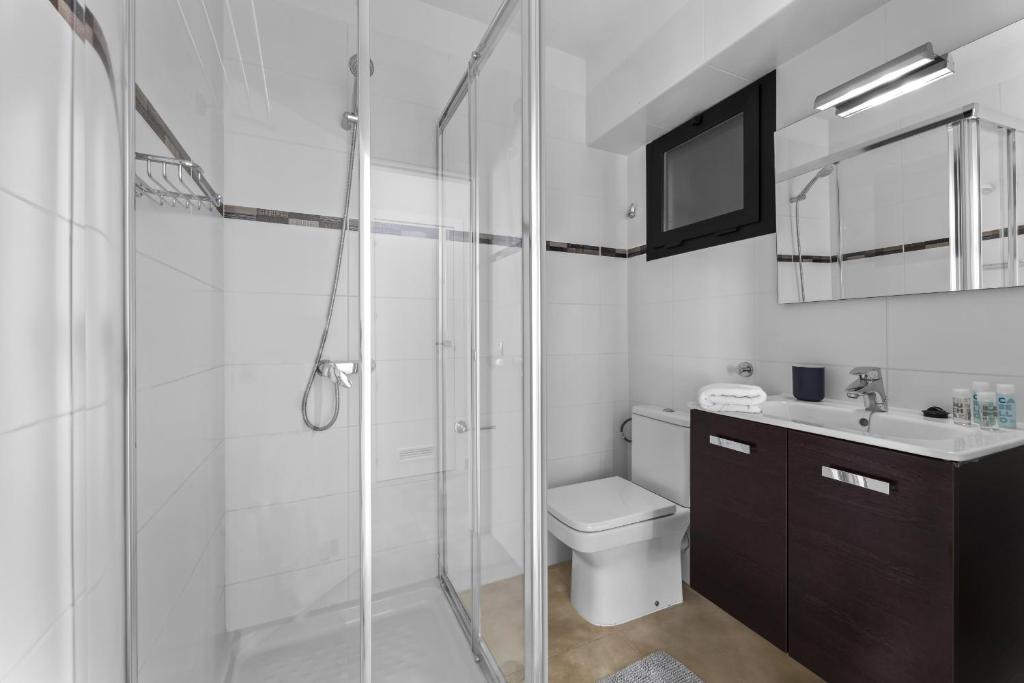 a bathroom with a shower and a toilet and a sink at Apartamentos Arrecife Playa in Arrecife