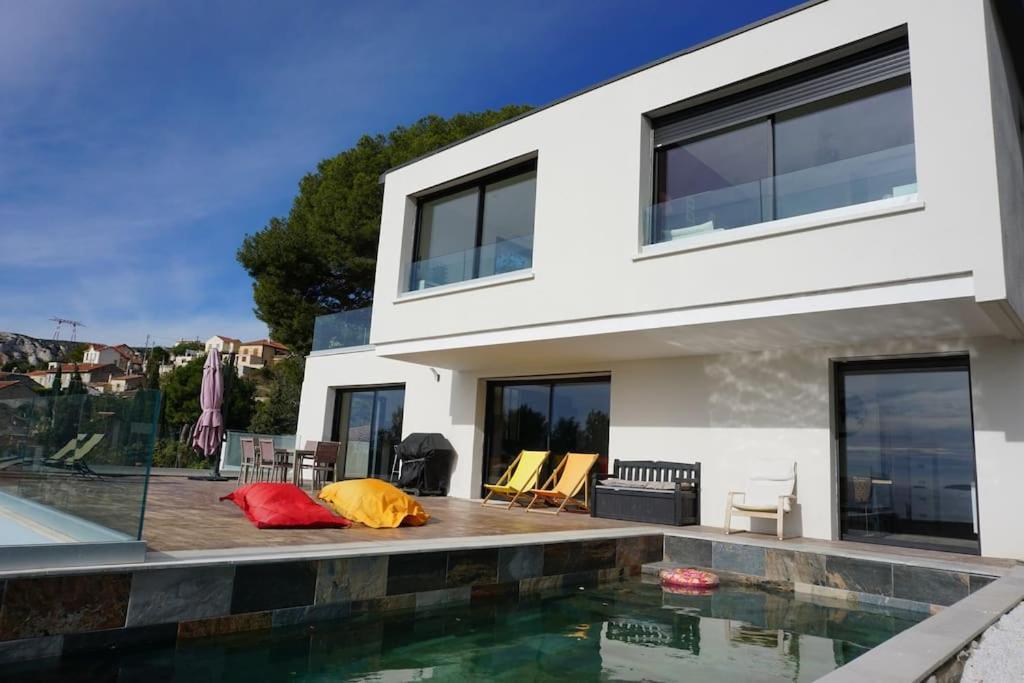 a white house with a swimming pool in front of it at ® L'imprenable - Somptueuse villa vue mer in Marseille