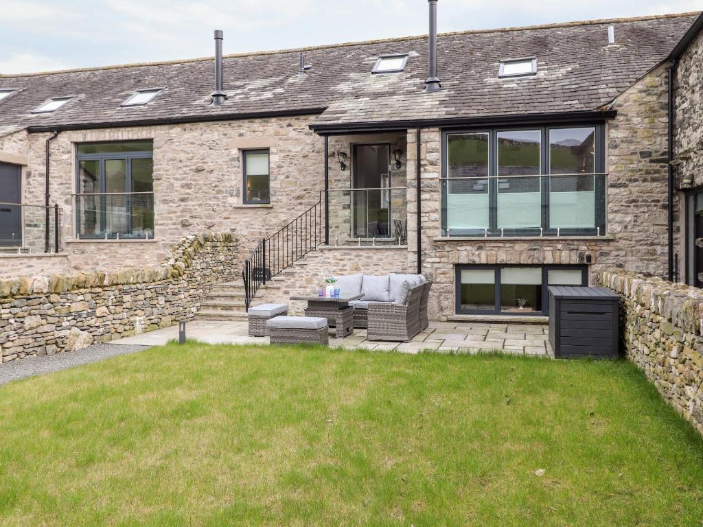 a stone house with a lawn in front of it at Adas Hideaway in Kendal