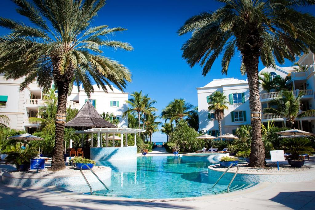 una piscina con palmeras en un complejo en Point Grace, en Grace Bay