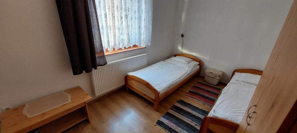 Cette petite chambre comprend 2 lits et une fenêtre. dans l'établissement Szabó József Evangélikus Vendégház, à Balassagyarmat