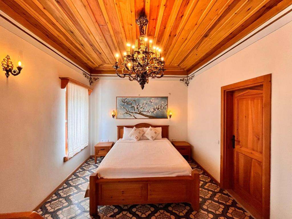 a bedroom with a bed and a chandelier at Eski Datça Otel in Datca