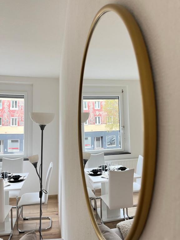 espejo que refleja un comedor con mesa y sillas en Apartment Vienna - Contactless Check-In, en Viena