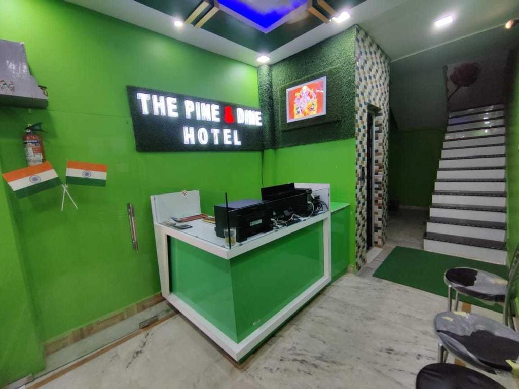 a room with a green wall with a hotel at OYO The Pine & Dine in Sonpur