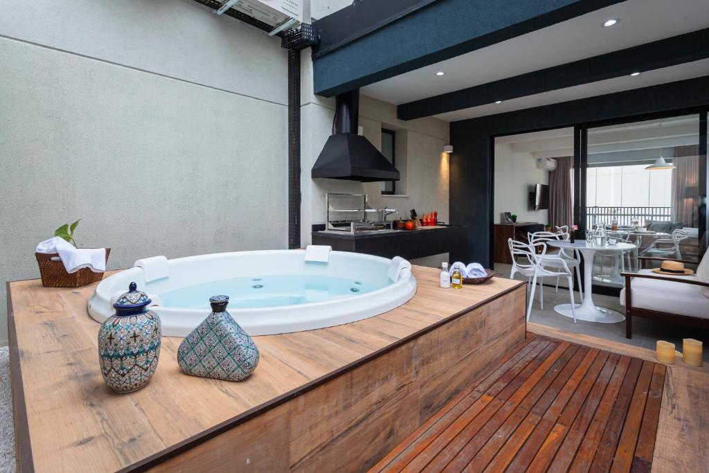 a large bath tub sitting on top of a wooden counter at Tabas - Pivô Match - Vila Nova Conceição in Sao Paulo