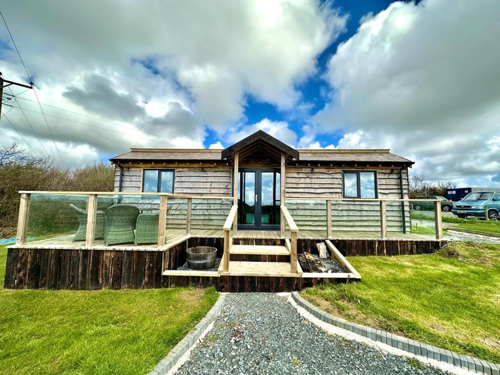 a log cabin with a porch and a house at The Piggery at Little Pig in Bude