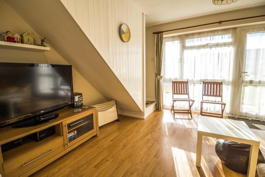 a living room with a large television and a table at Great 3 Bedroom Chalet To Hire With In Hemsby, Great Seaside Break! Ref 18194b in Hemsby