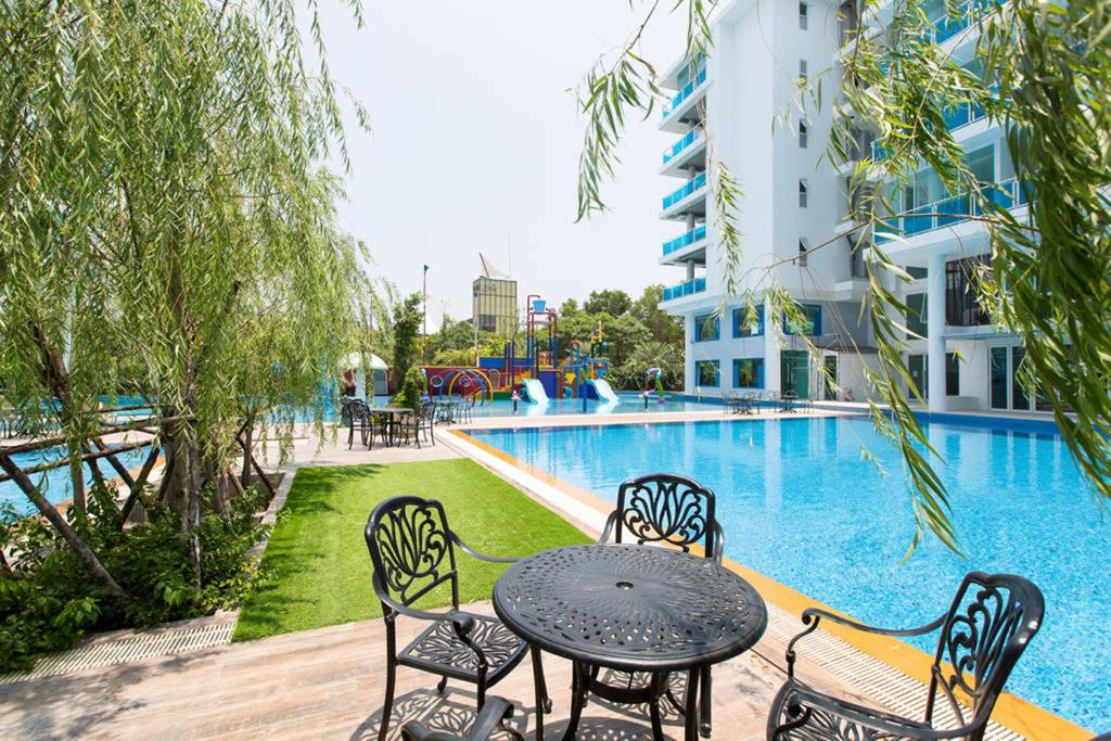 una mesa y sillas junto a una piscina en My Resort Condo in Hua Hin E204, en Hua Hin