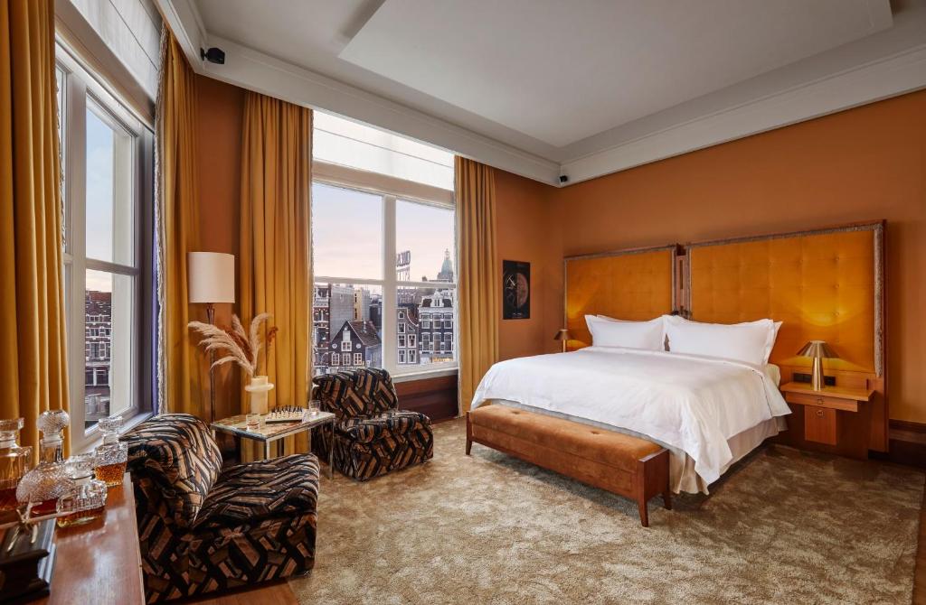 a bedroom with a bed and a large window at De L’Europe Amsterdam – The Leading Hotels of the World in Amsterdam