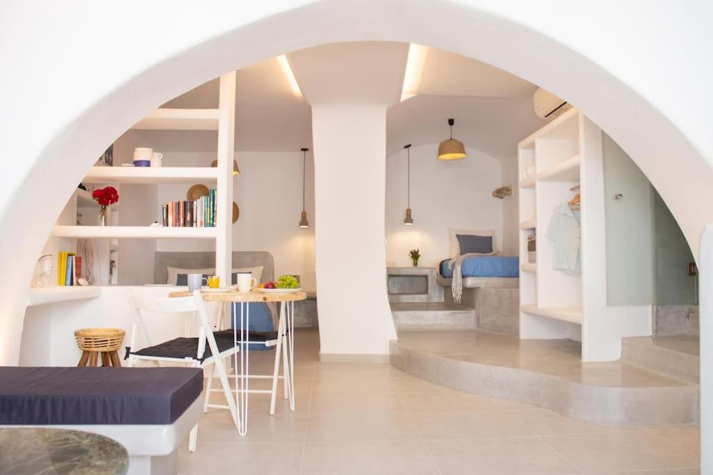 an archway in a living room with a table and a bedroom at Traditional Arch House Paros in Márpissa