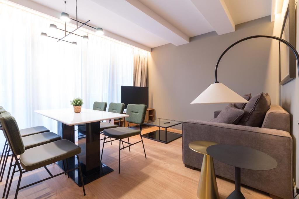 ein Wohnzimmer mit einem Sofa, einem Tisch und Stühlen in der Unterkunft Old Town Apartments by Staynnapartments in Bilbao