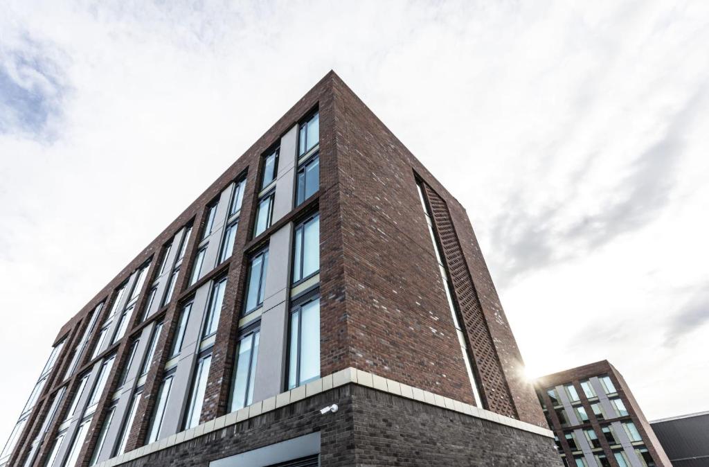 a brick building with glass windows on the side of it at For Students Only Ensuite Bedrooms with Shared Kitchen at Triumph House in Nottingham in Nottingham