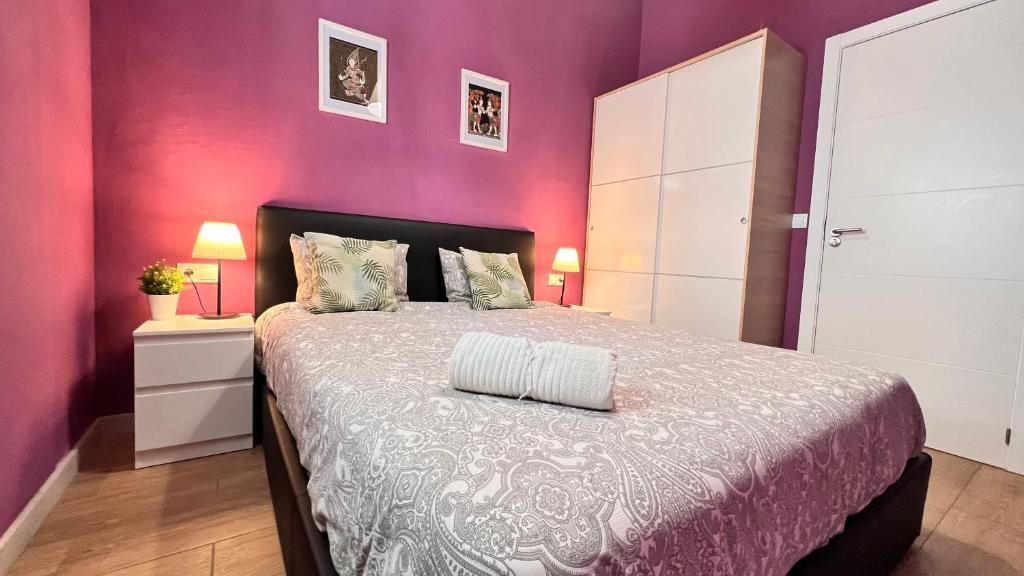 a bedroom with a bed with a purple wall at New Camp Nou Apartment/Diret Airport,Beautiful in Hospitalet de Llobregat