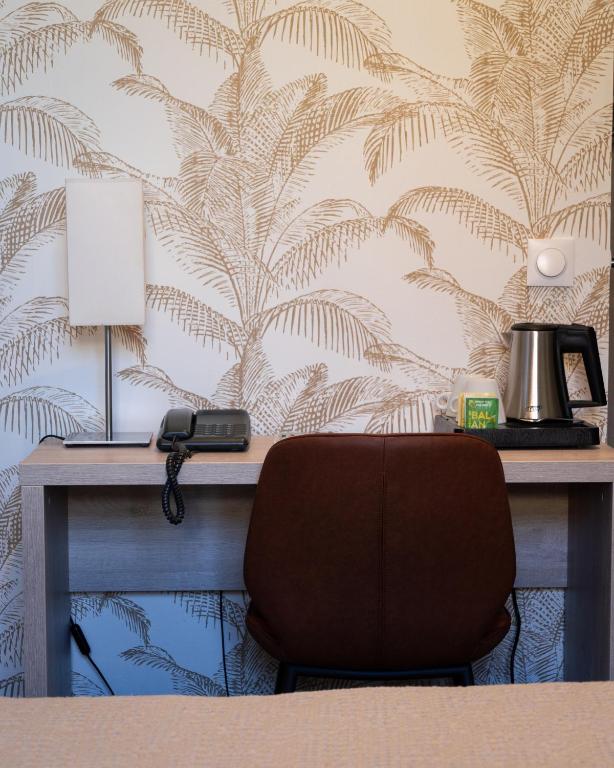 a desk with a chair in front of a wall at Hotel Miramar in Cap d'Ail
