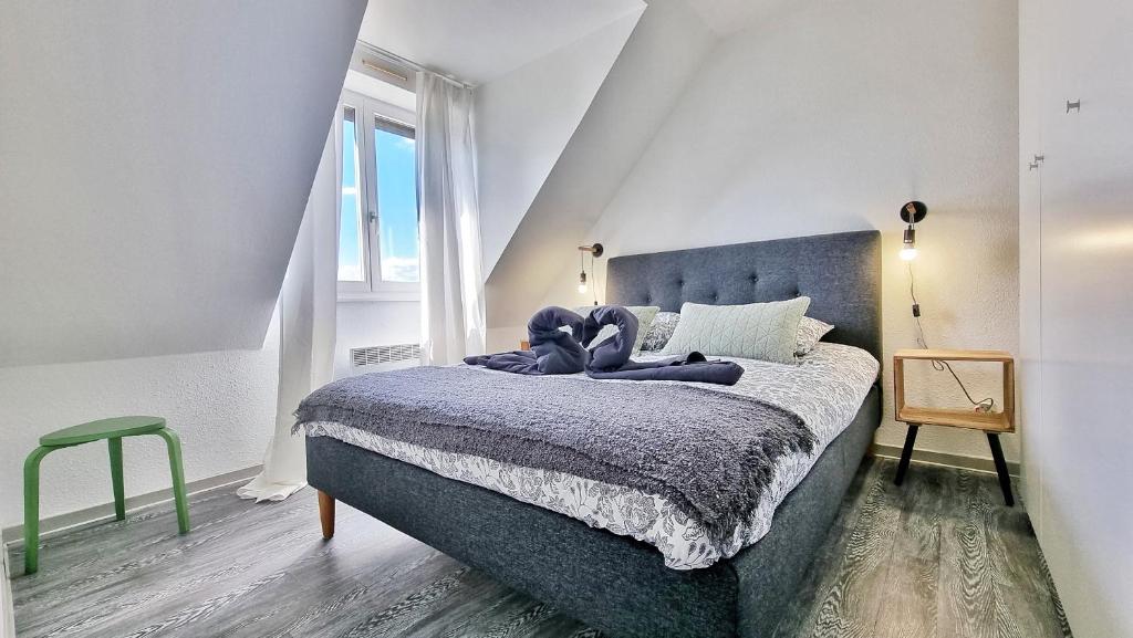 科爾馬的住宿－Colmar Mon Amour-CHIC-GARAGE-FIBRE-RBNB，一间卧室配有一张带蓝色毯子的床
