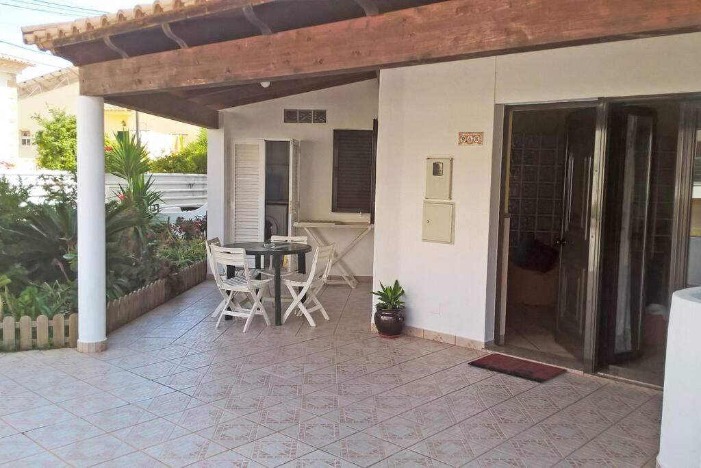 una casa con patio con mesa y sillas en Nice Studio, large terrace & beautiful pool, en Lagos