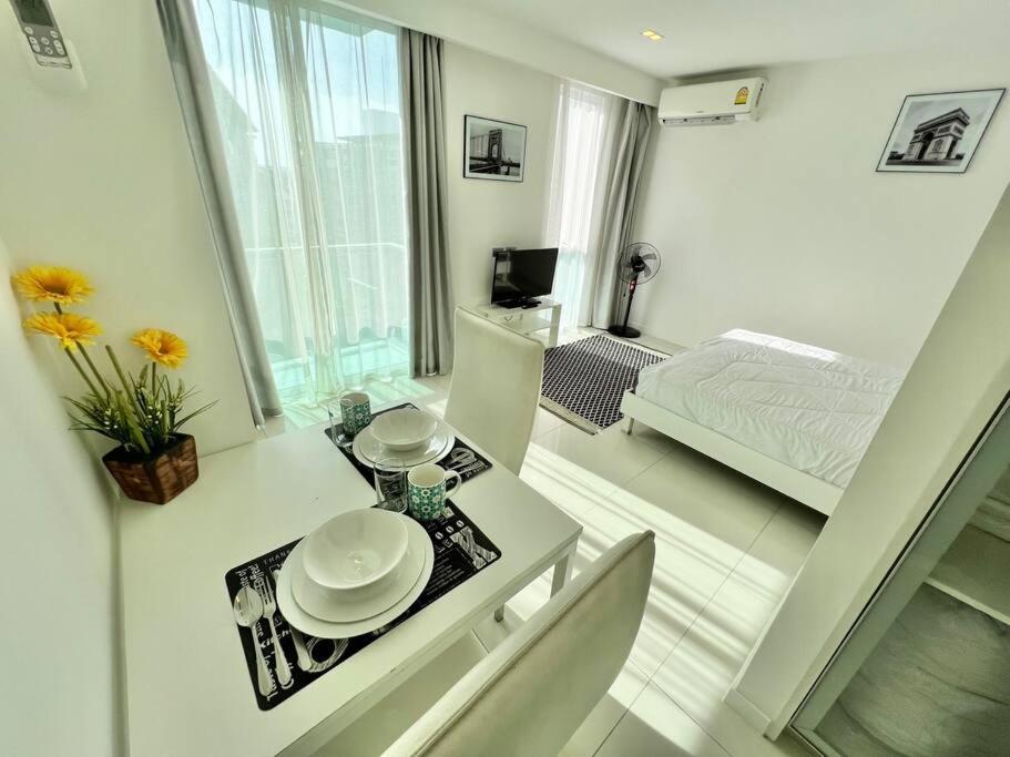 a white room with a table and a bed at COOL VIEW Studio in CCR Condo in Pattaya Central