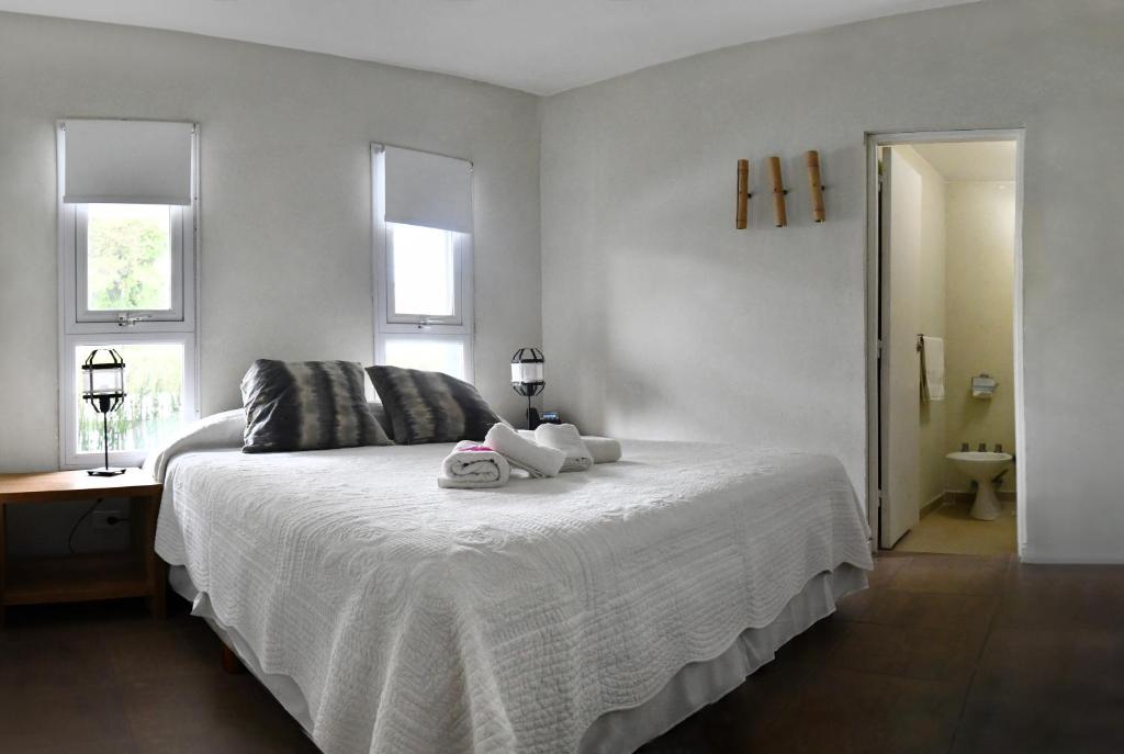 a bedroom with a bed with two stuffed animals on it at O2 Hotel Villa Gesell in Villa Gesell