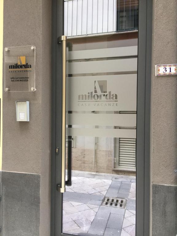 een deur naar een gebouw met een bord erop bij Casa vacanze A Milorda in Letojanni