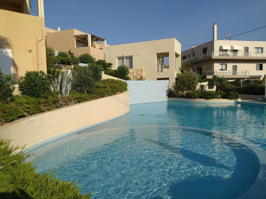 a large swimming pool in front of a building at One bedroom apartment with pool in Plakias
