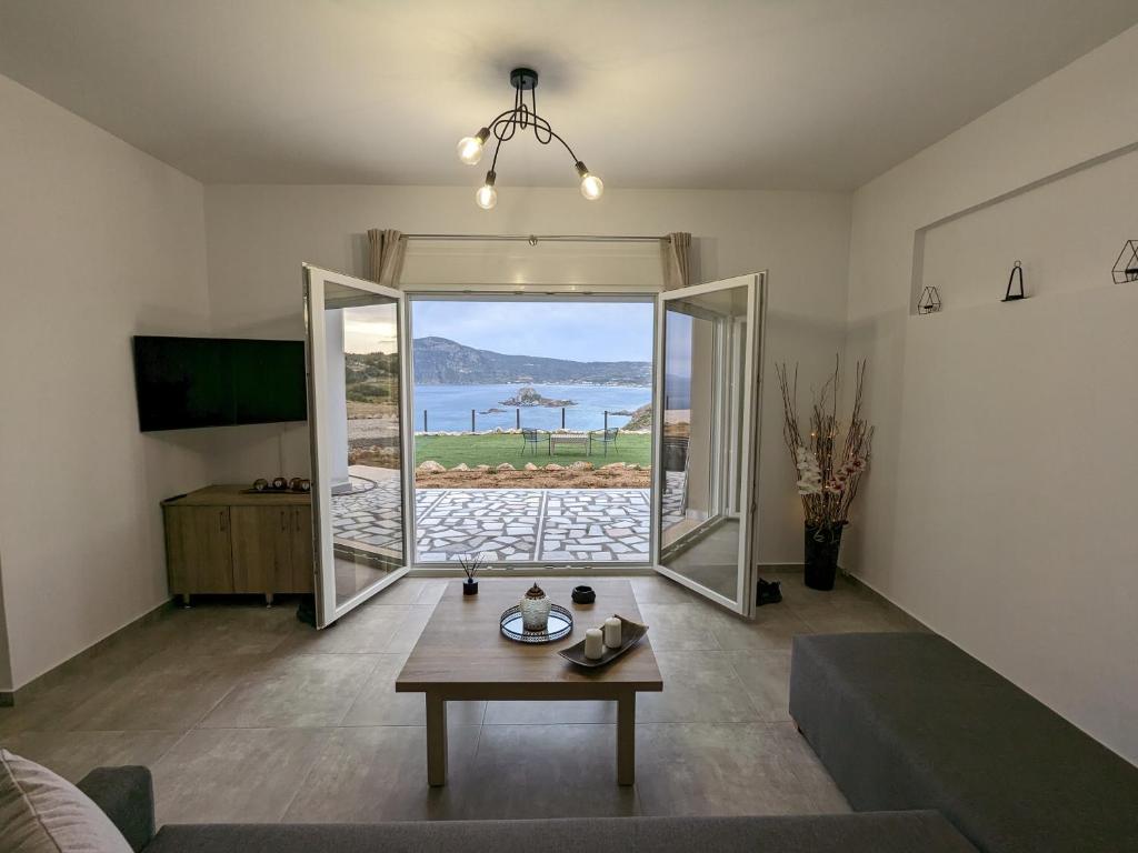 a living room with a table and a view of the ocean at Cute apartments in Kefalos