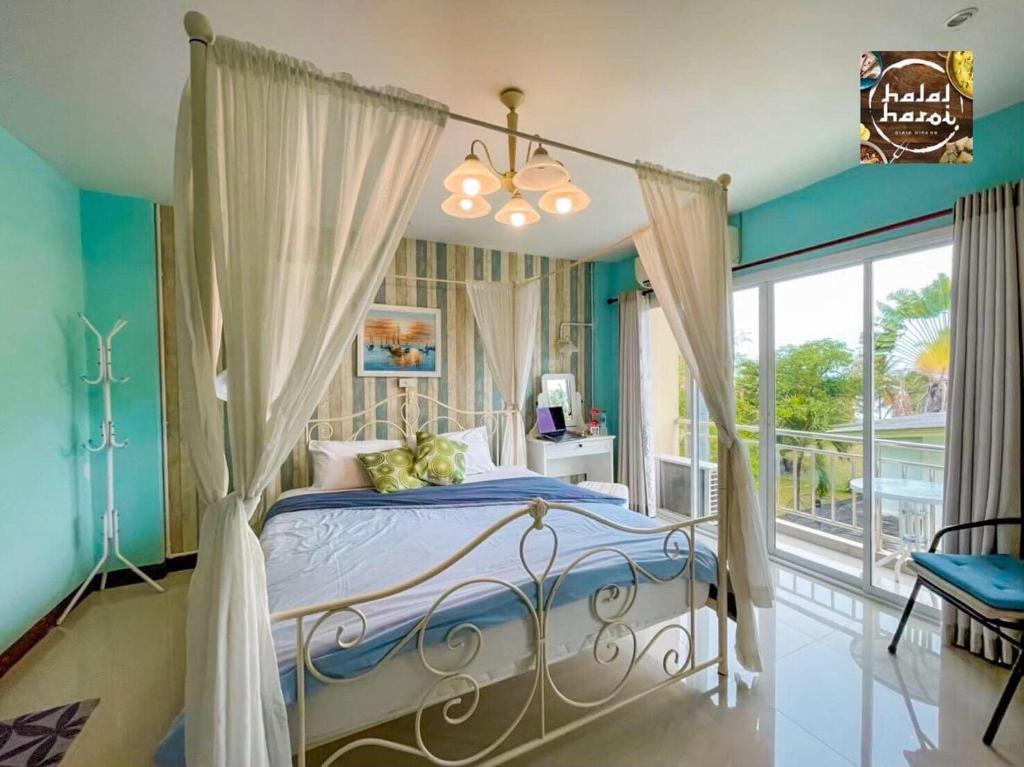 a bedroom with a bed with blue walls and a window at MOOZ HUAHIN in Hua Hin