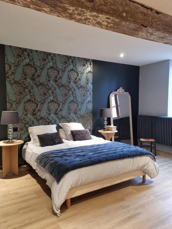 1 dormitorio con 1 cama grande y pared azul en L'Aupinouse Chambre double Giroflée avec salle de bain privative, en La Suze-sur-Sarthe