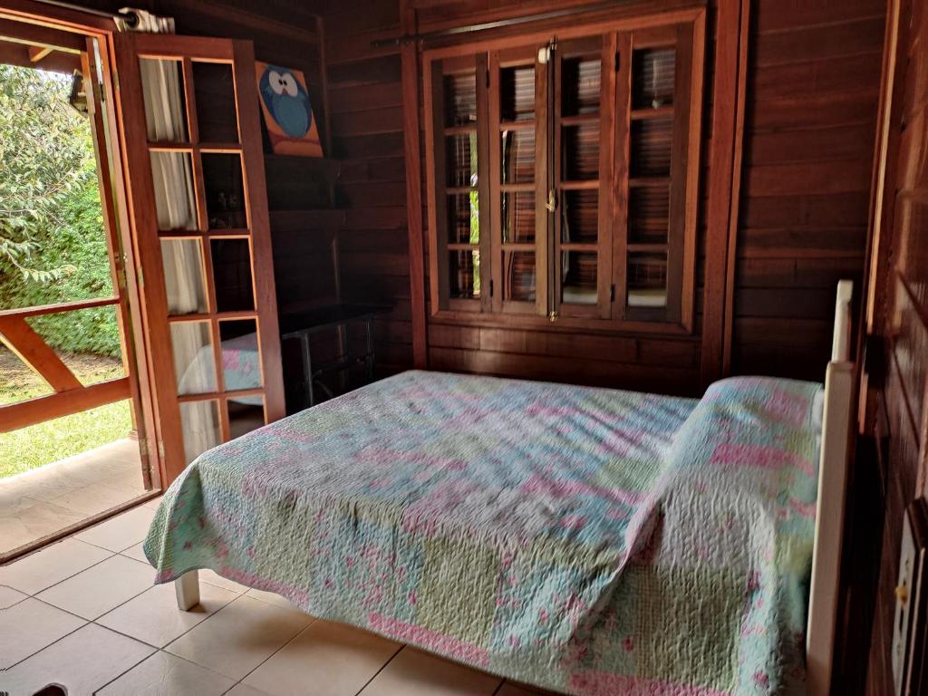 Paz na Serra Teresopolis في تيريسوبوليس: غرفة نوم مع سرير في غرفة مع نافذة
