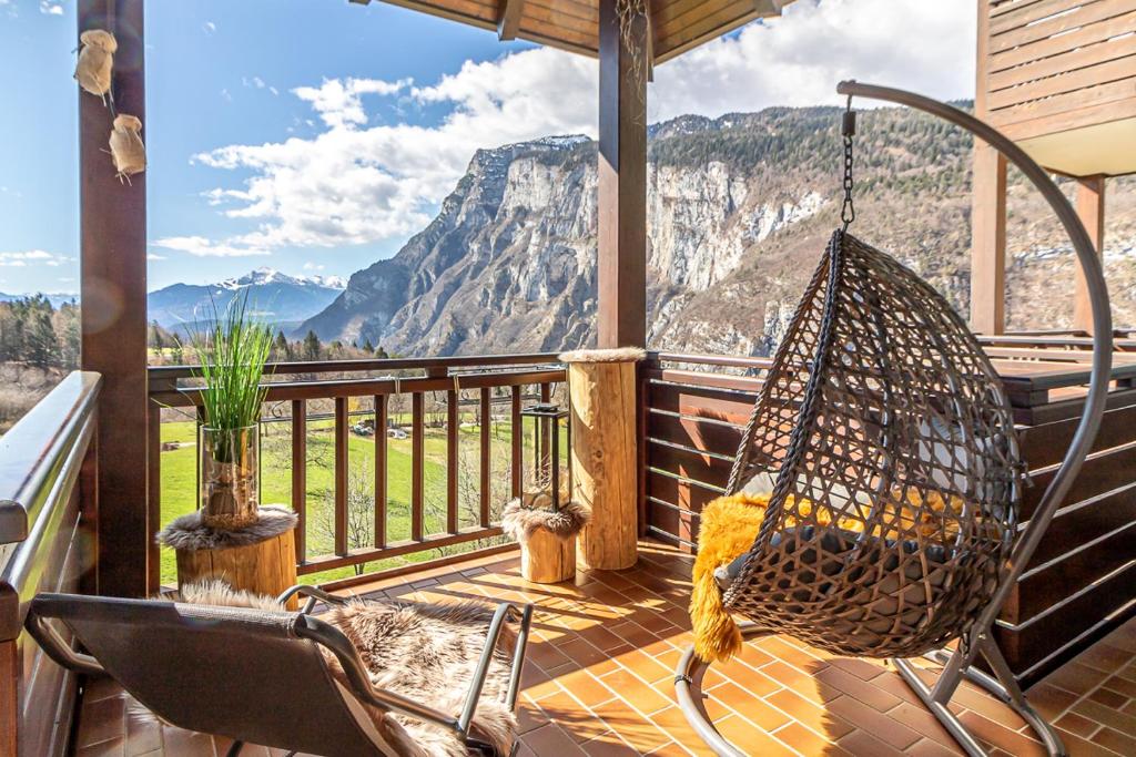 a porch with a hammock and a view of a mountain at Hotel Arcobaleno in Fai della Paganella