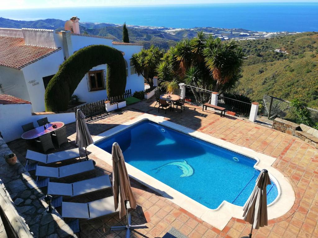 Cette villa dispose d'une piscine et offre une vue sur l'océan. dans l'établissement La Montaña Del Oro, à Sayalonga