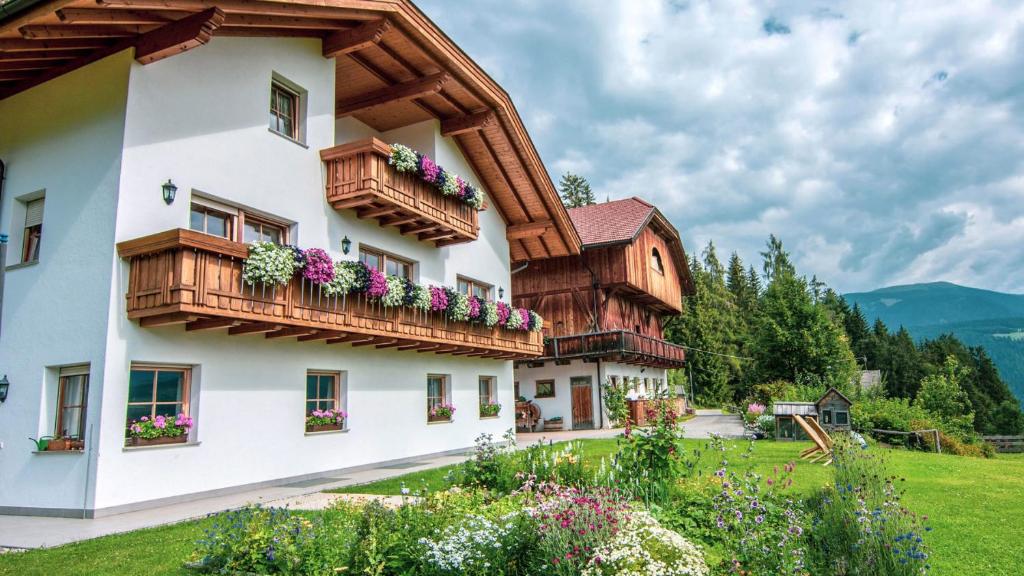 um edifício com caixas de flores nas varandas em Kranebitterhof Apt Alpenrose em Valdaora