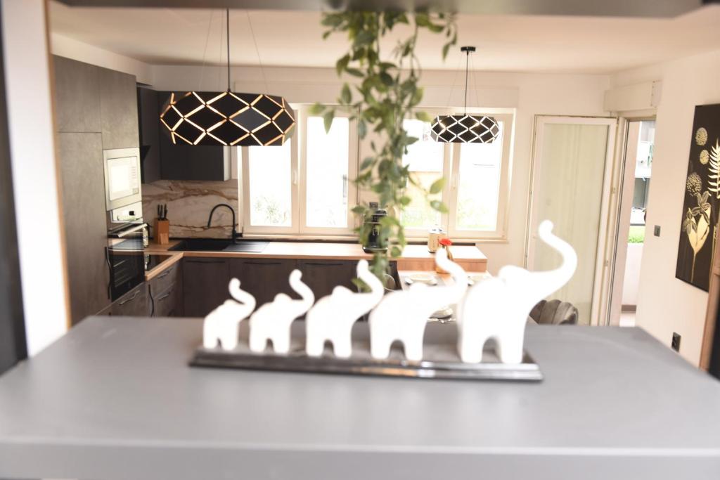 una cocina con 4 gatos blancos en una barra en Navigo, en Ploče