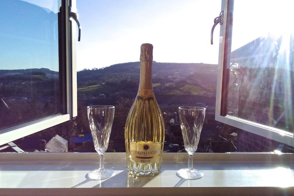 una botella de vino sentada en una mesa con dos copas en Birds Nest, Romantic getaway with stunning views en Matlock