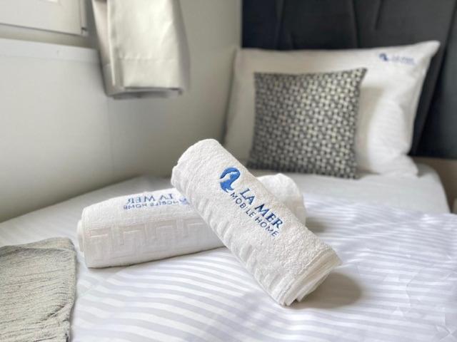 uma cama com duas toalhas em cima em La Mer Mobil Home em Biograd na Moru